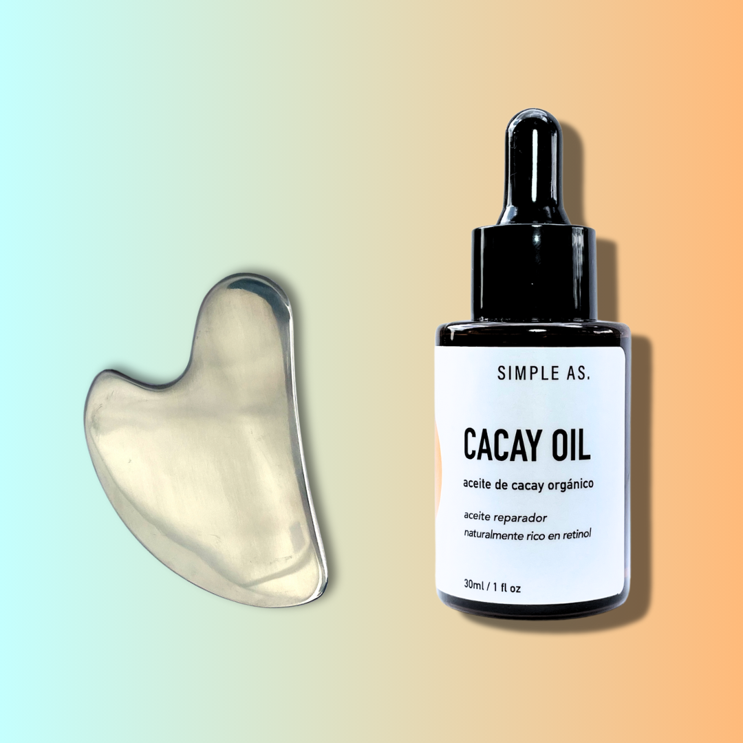 gua sha de acero con aceite de cacay con fondo blanco.
